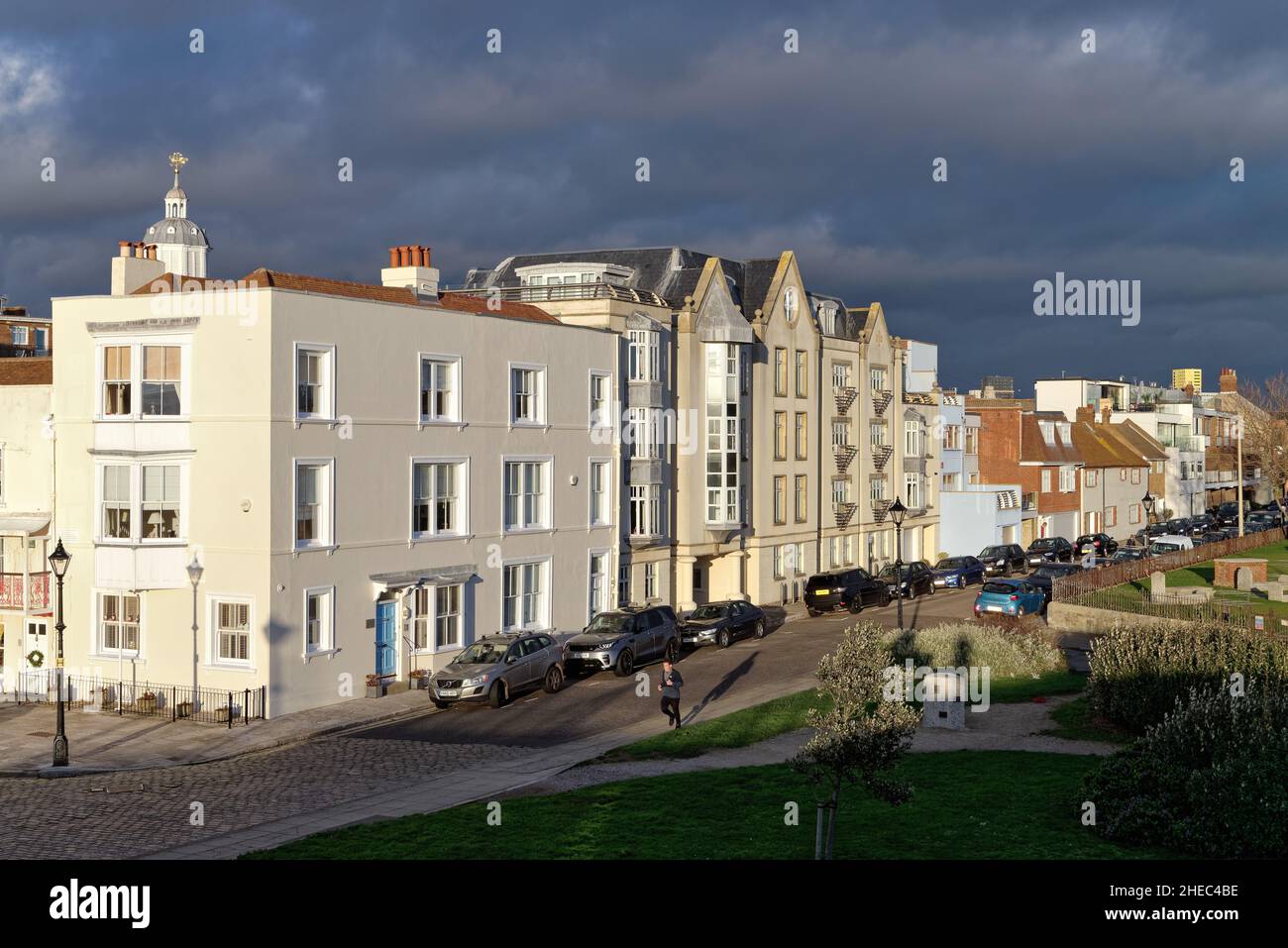 Old historic houses on Grand Parade and Penny Street illuminated by a dramatic winter sunset against a dark sky, old Portsmouth Hampshire England UK Stock Photo