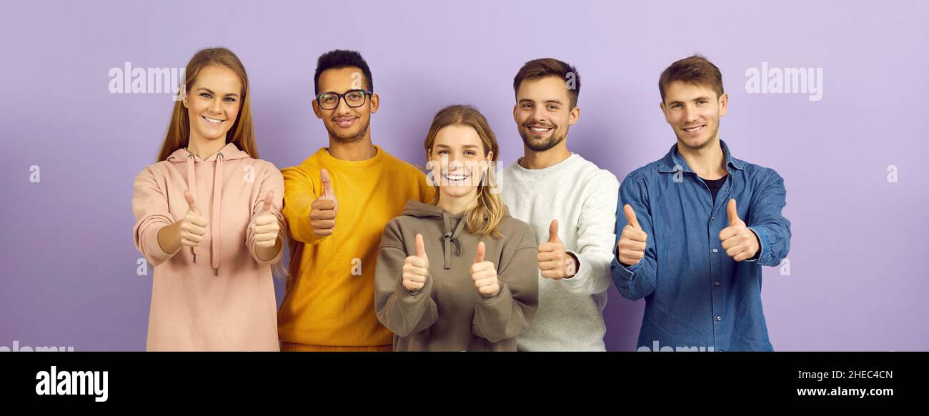 Banner with diverse group of happy young people smiling and showing thumbs up together Stock Photo