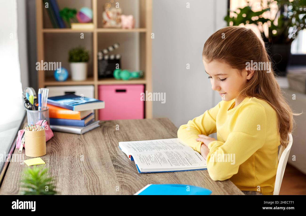 little student girl reading book at home Stock Photo - Alamy