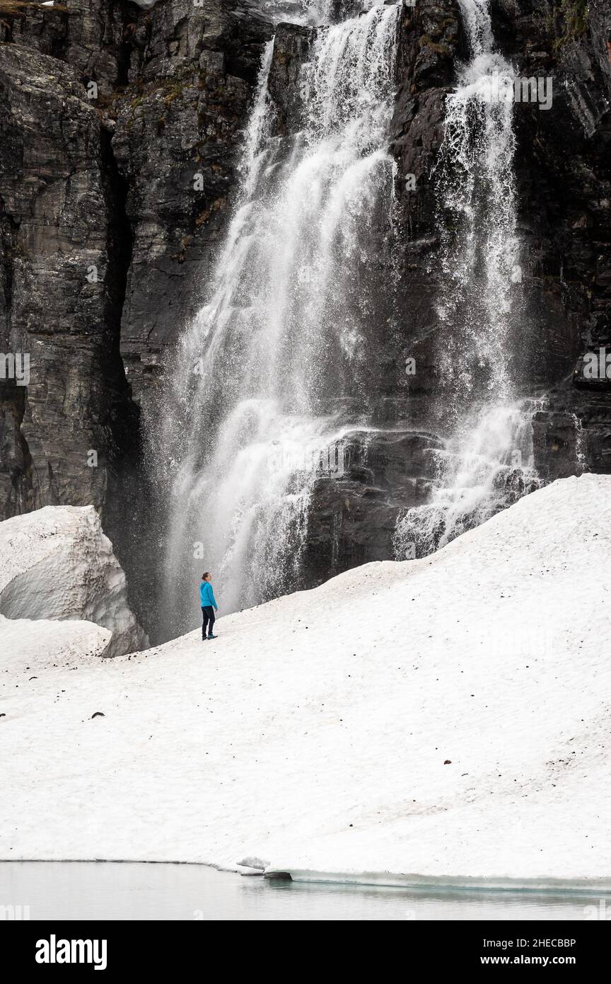 Person standing on snow under a waterfall, Aurlandsfjellet, Norway Stock Photo
