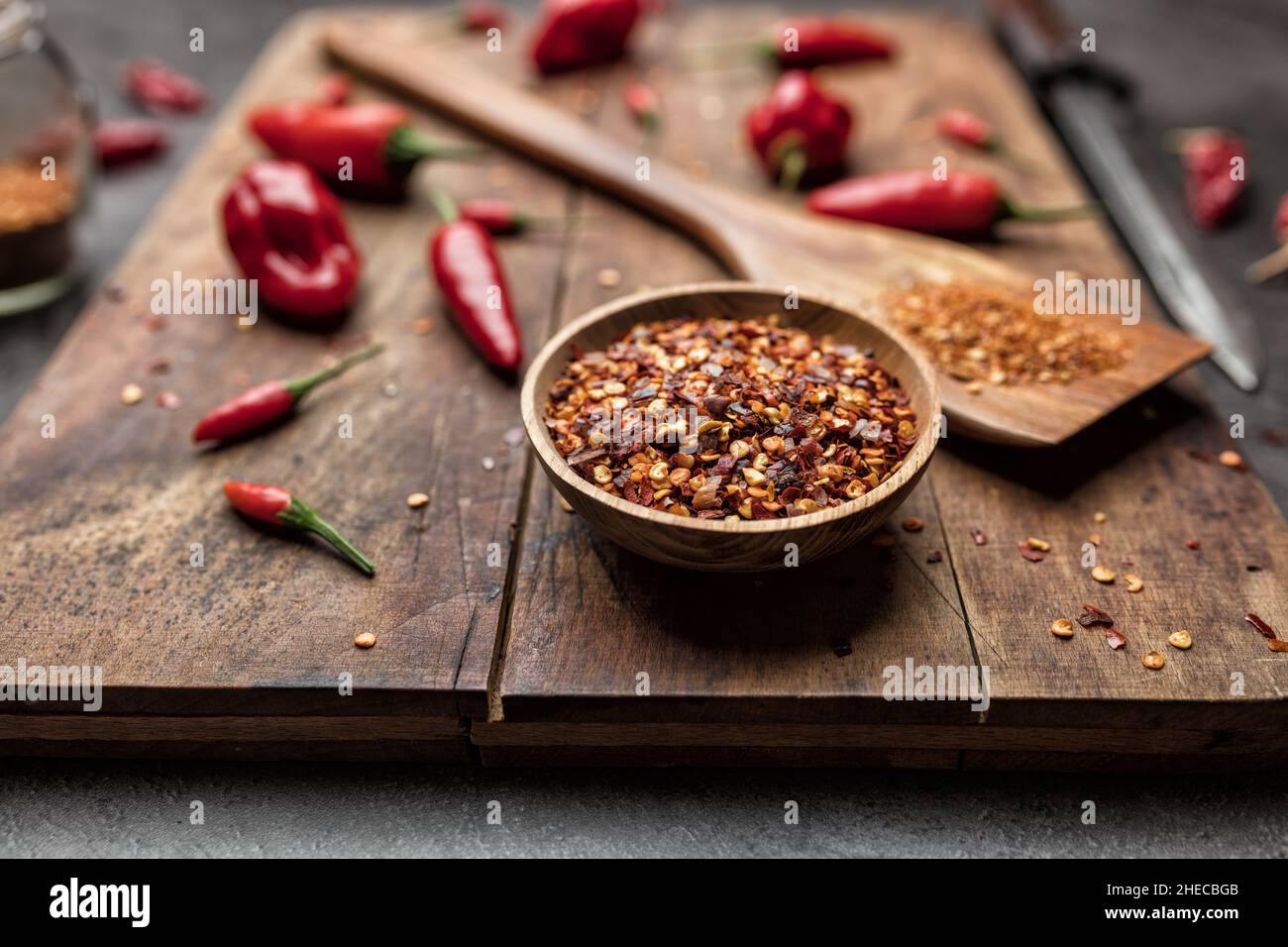 Variety of fresh and dried chili peppers on rustic background Stock Photo