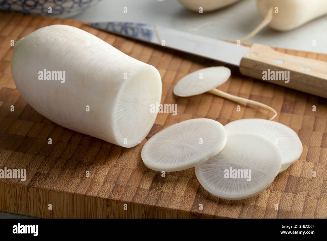 Fresh white daikon radish and slices on a cutting board close up Stock Photo
