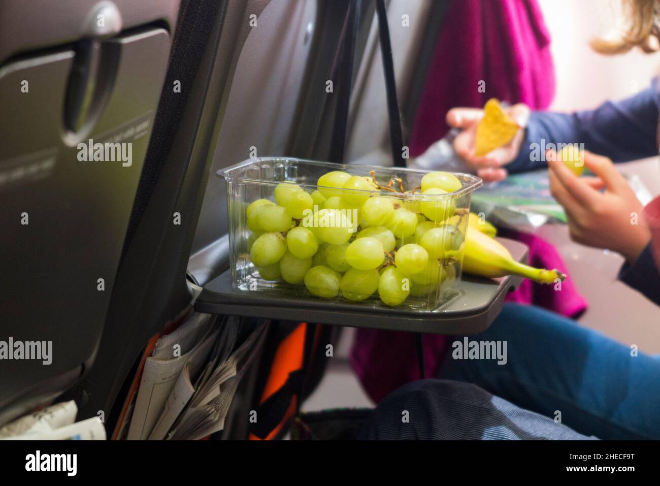 Healthy food, grapes and banana fruit, on a seat tray table, on an