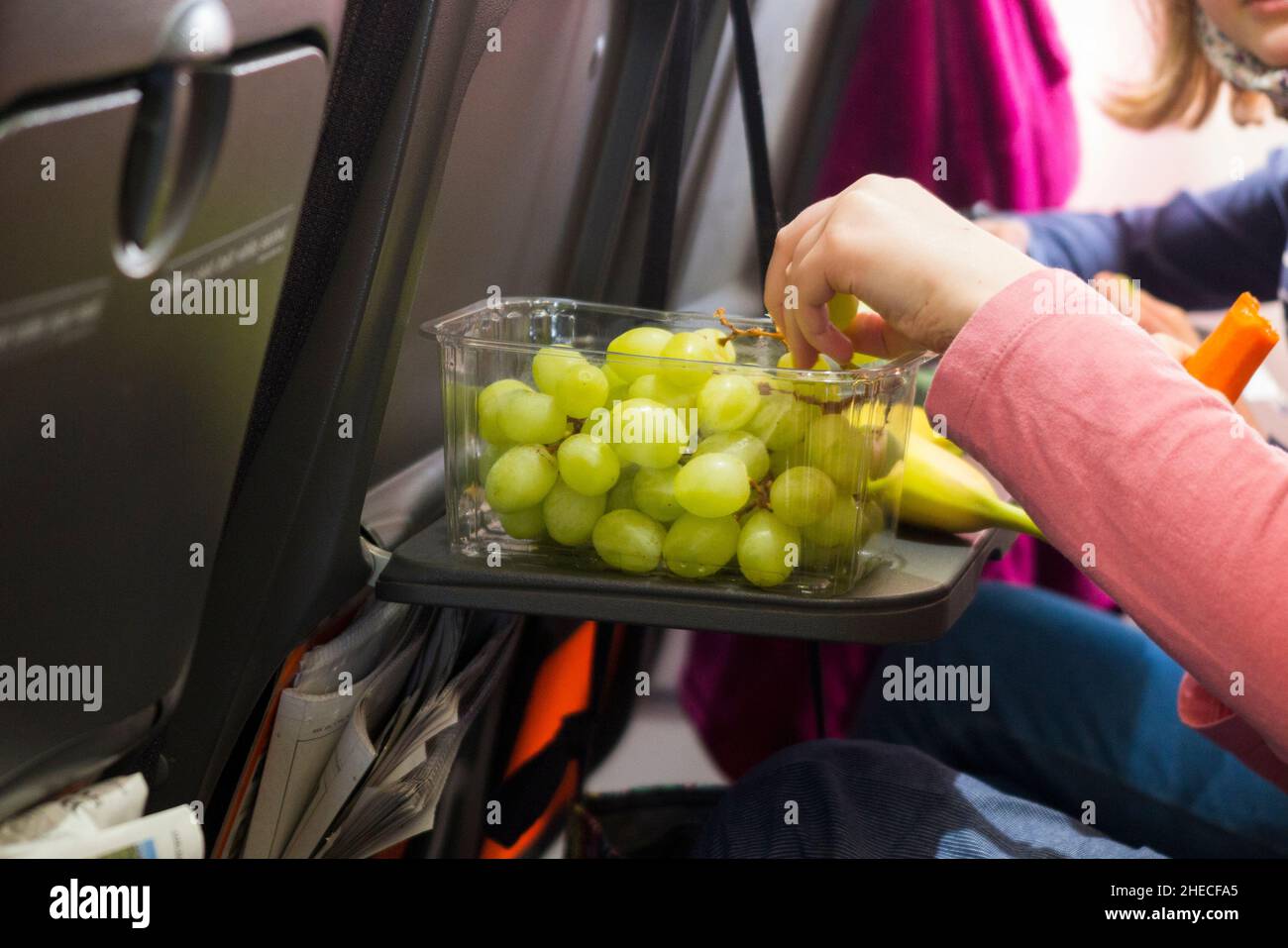Healthy food, grapes and banana fruit, on a seat tray table, on an
