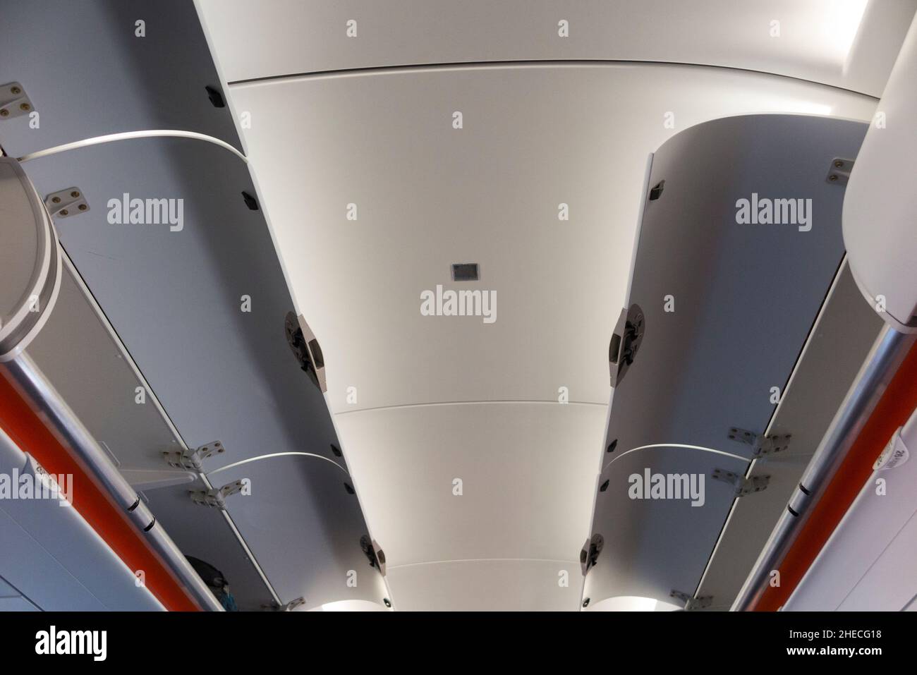 Overhead passenger locker / lockers / compartment / compartments for stowing passengers bags cabin luggage, either side of the ceiling, on an Easyjet Airbus A320 or A319 plane. (128) Stock Photo
