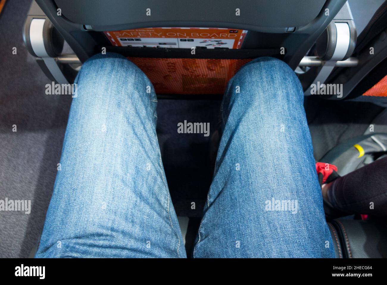 Passenger sitting in seat on an airplane / aeroplane / plane showing
