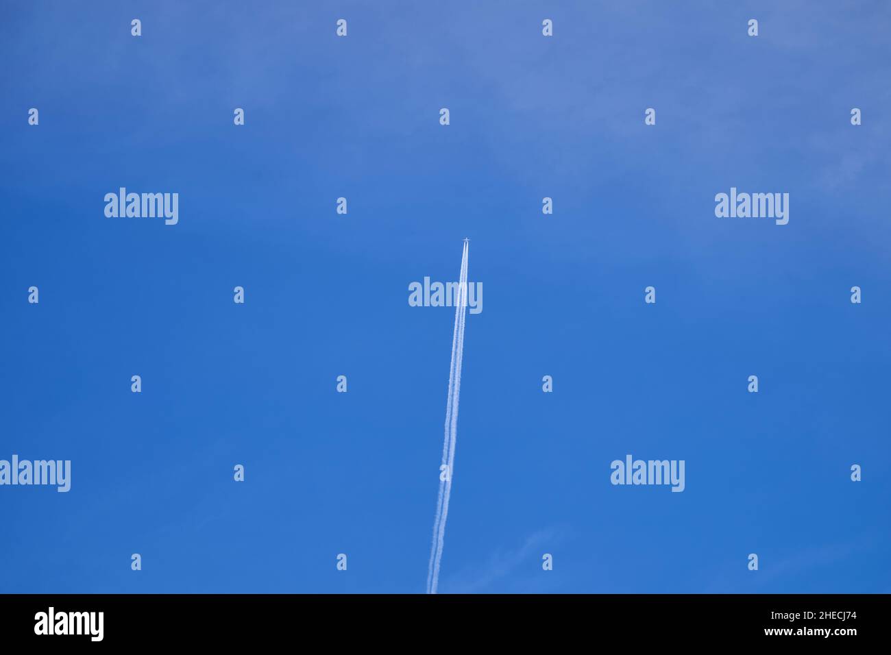Airplane flying in the blue sky, producing a condensation trail Stock Photo