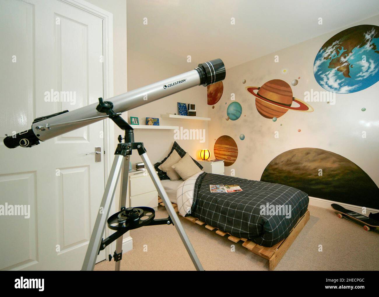 Astronomy themed childs childrens boys bedroom, telecope,planets wall  paintings, bed, skateboard Stock Photo - Alamy