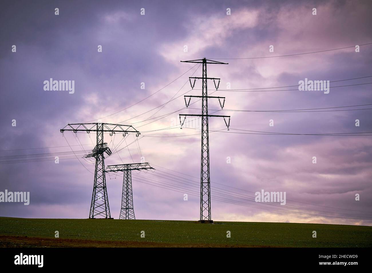 Hochspannung Strommasten mit elektrischen Leitungen mit dunklen Wolken Stock Photo