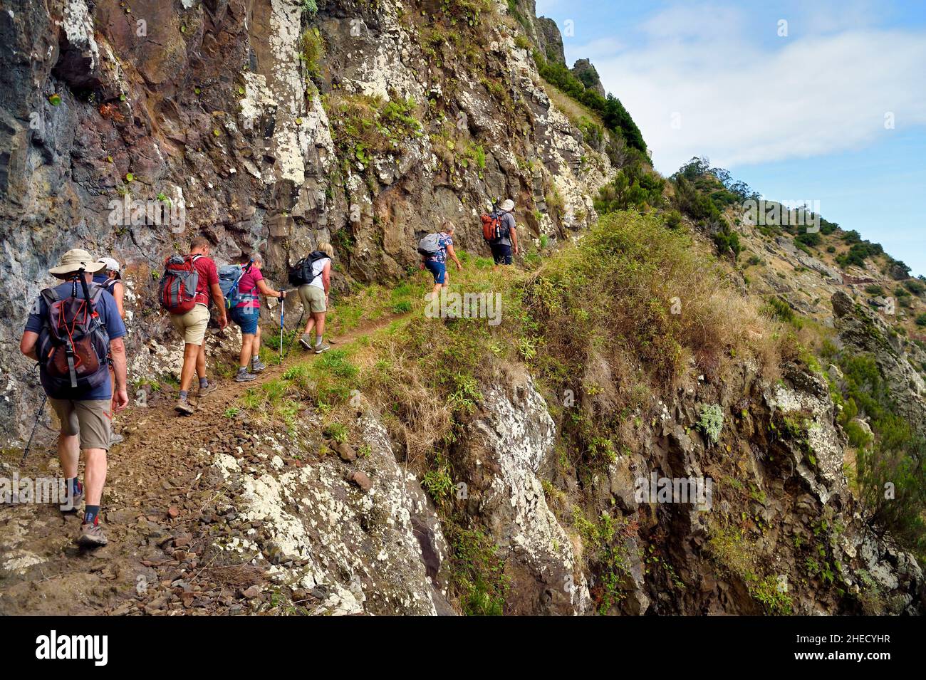 Portugal, Madeira Island, hike from Machico to Porto da Cruz by the Vereda do Larano, hikers on the path carved into the side of the wall of the cliff of Larano Stock Photo