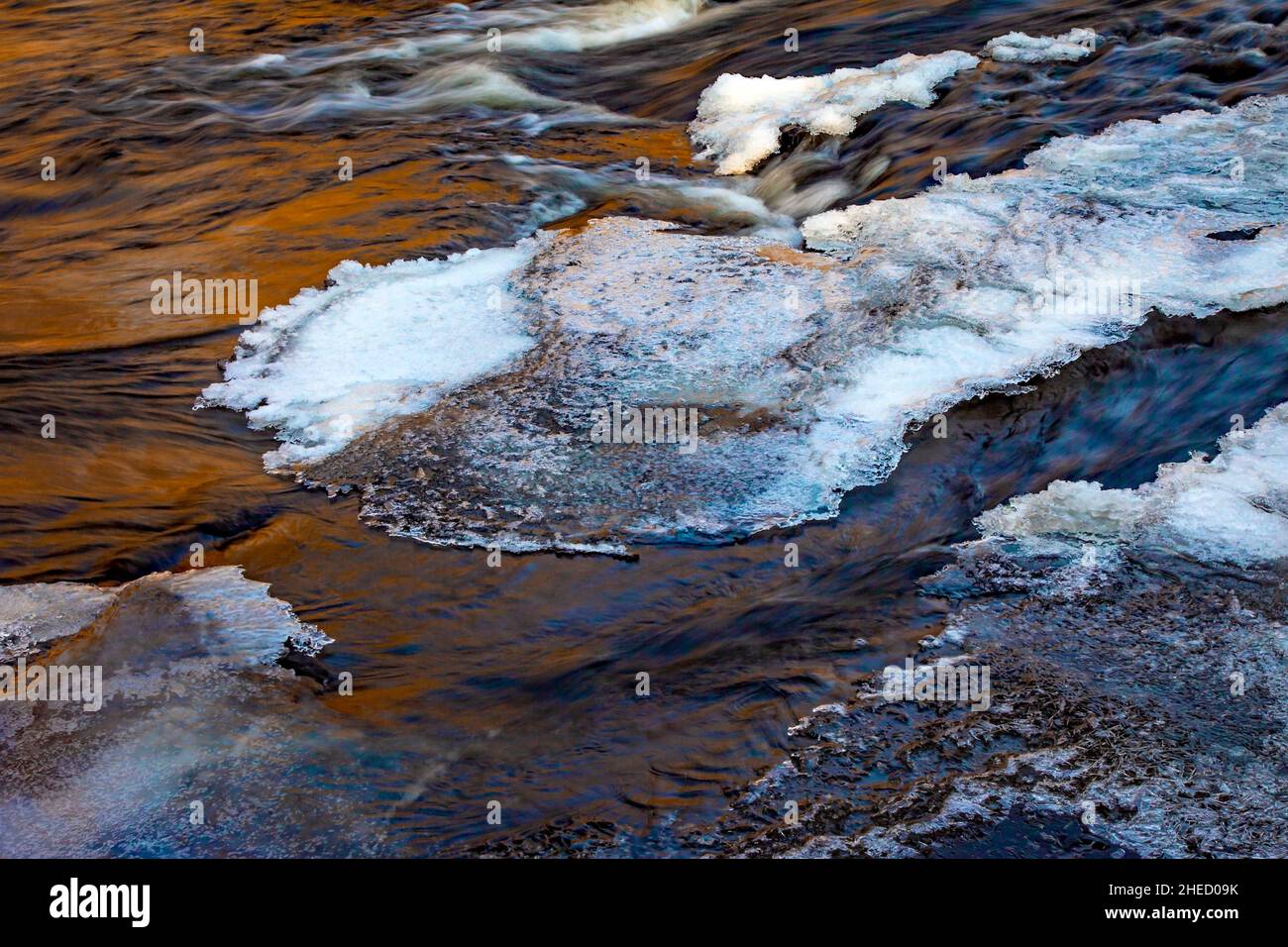 Ice and late afternoon reflections on Tobyhanna Creek in Pennsylvania's Pocono Mountains in early winter. Stock Photo