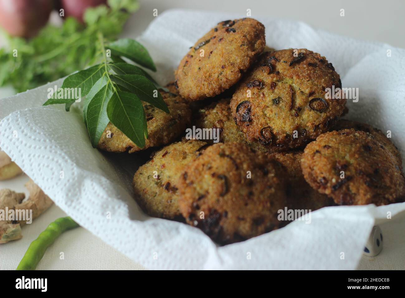 Kodo millet fritters. A crispy fritters made with cooked and mashed kodo millet flour and spices. Disk shaped deep fried evening snack. Commonly known Stock Photo