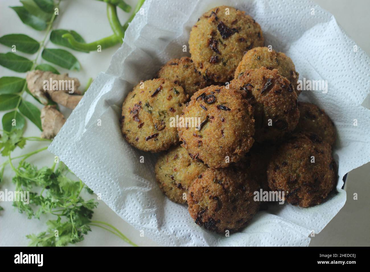 Kodo millet fritters. A crispy fritters made with cooked and mashed kodo millet flour and spices. Disk shaped deep fried evening snack. Commonly known Stock Photo