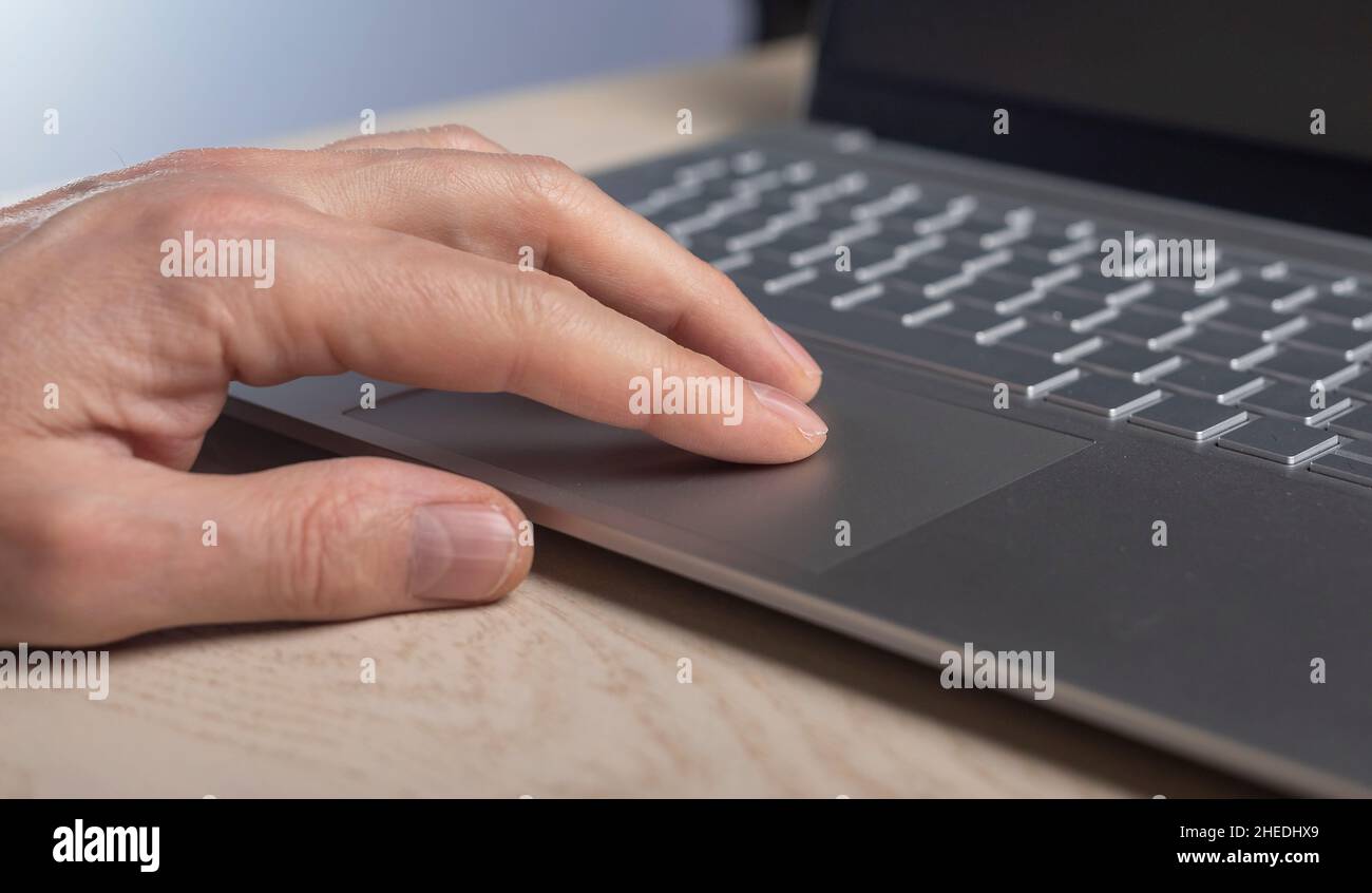 Fingers on laptop touchpad, scrolling process close up. Stock Photo