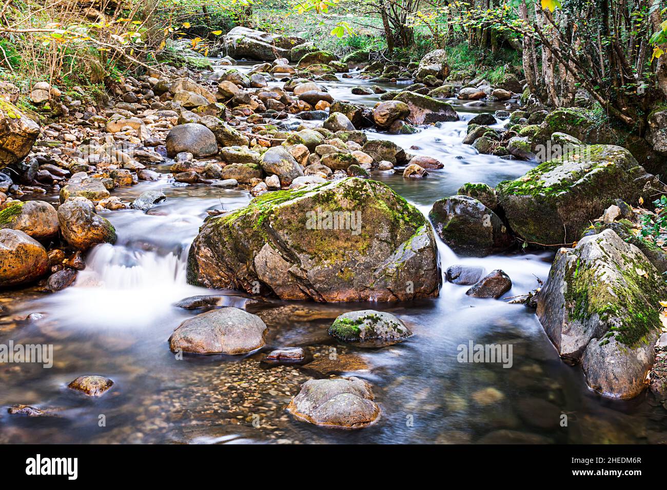 Photograph of a river with silky water effect.The photo has been taken on the Alba route that starts from the famous Asturian town Soto de Agues. Stock Photo