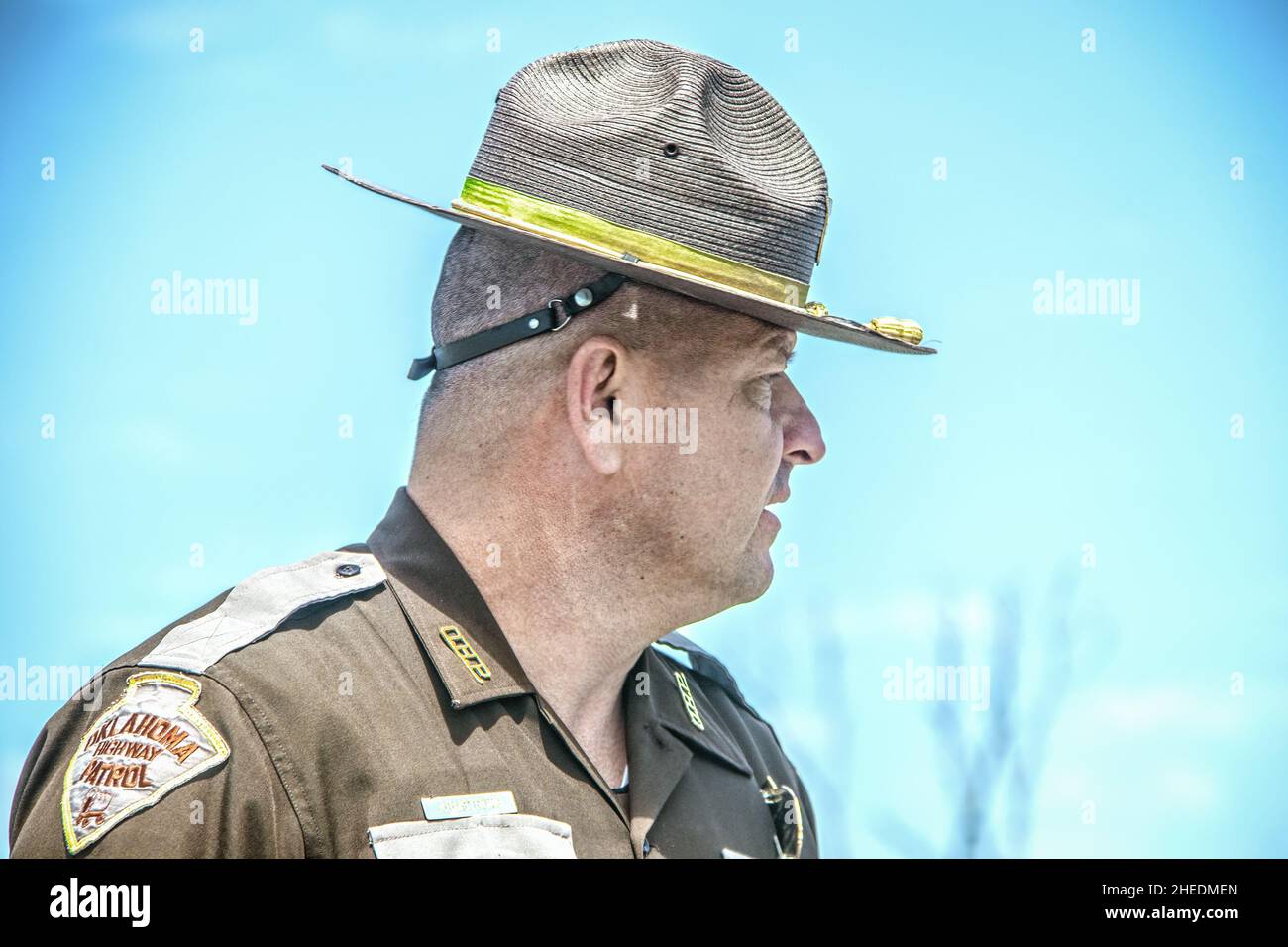 5-14-2020 Cushing USA - Oklahoma highway patrolman in uniform and hat against blue sky  head and shoulders profile closeup Stock Photo
