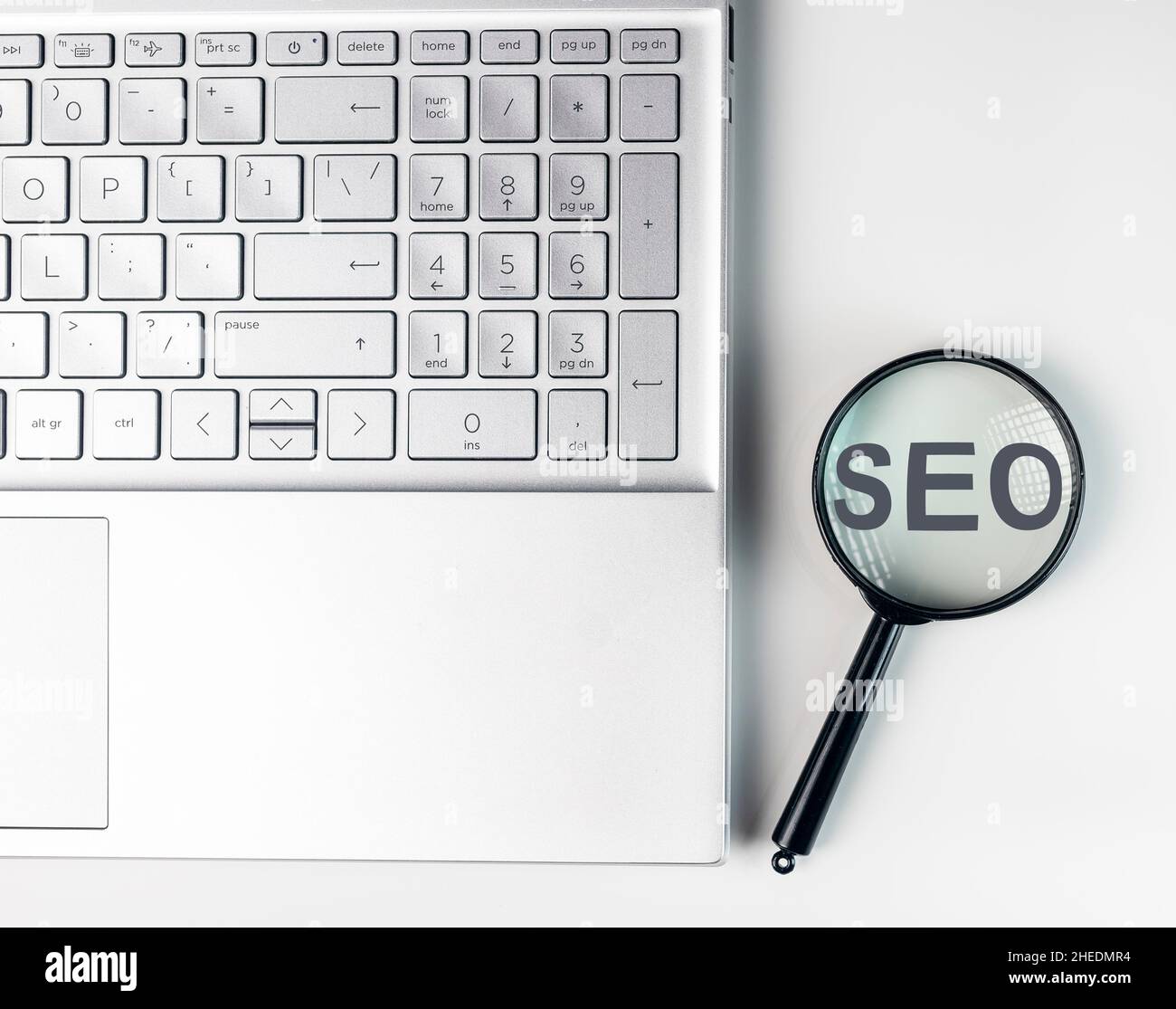 SEO, search engine optimization concept. Word through magnifying glass. Stock Photo