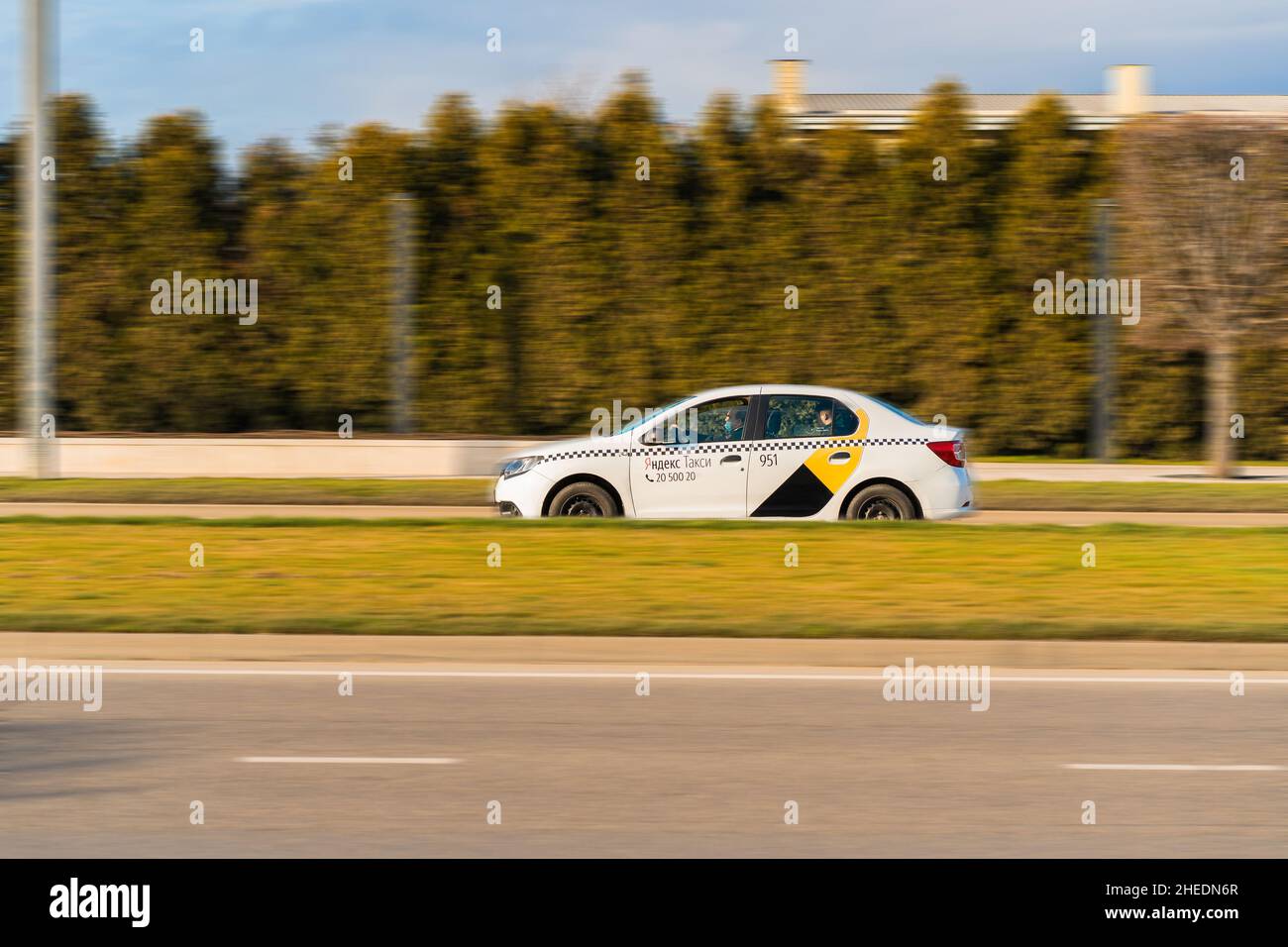 Krasnodar, Russia - January 7 2022: white Renault Logan Yandex taxi is driving fast on the street. Stock Photo