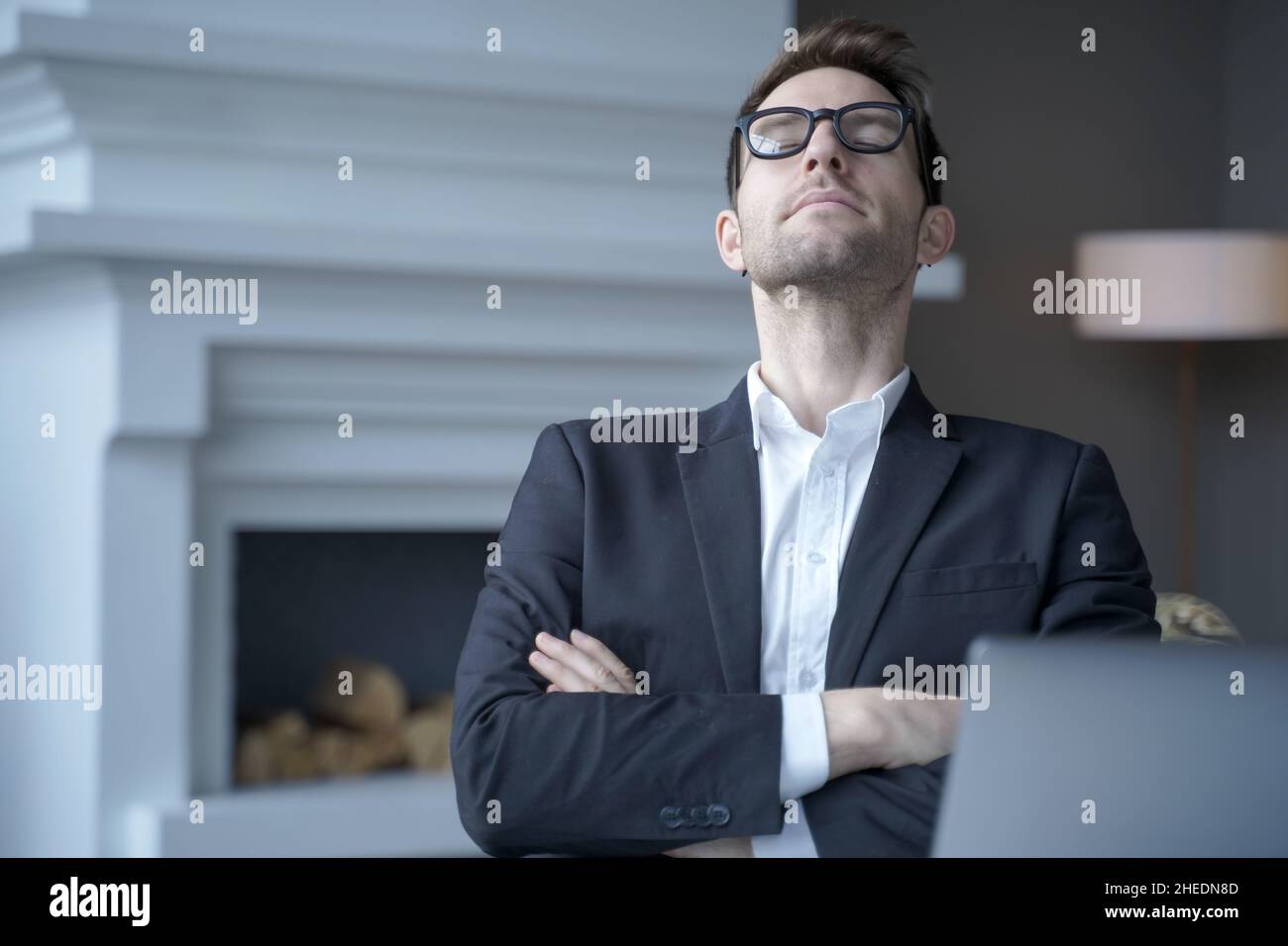 Mediative german businessman sit at desk with eyes closed taking rest from computer work Stock Photo