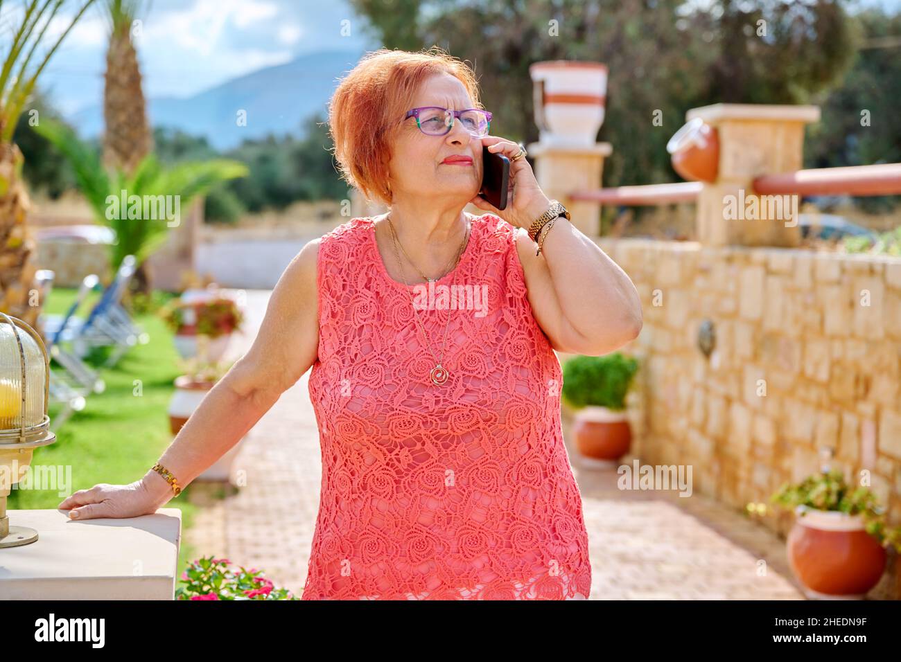 Elderly woman talking on a mobile phone outdoors Stock Photo