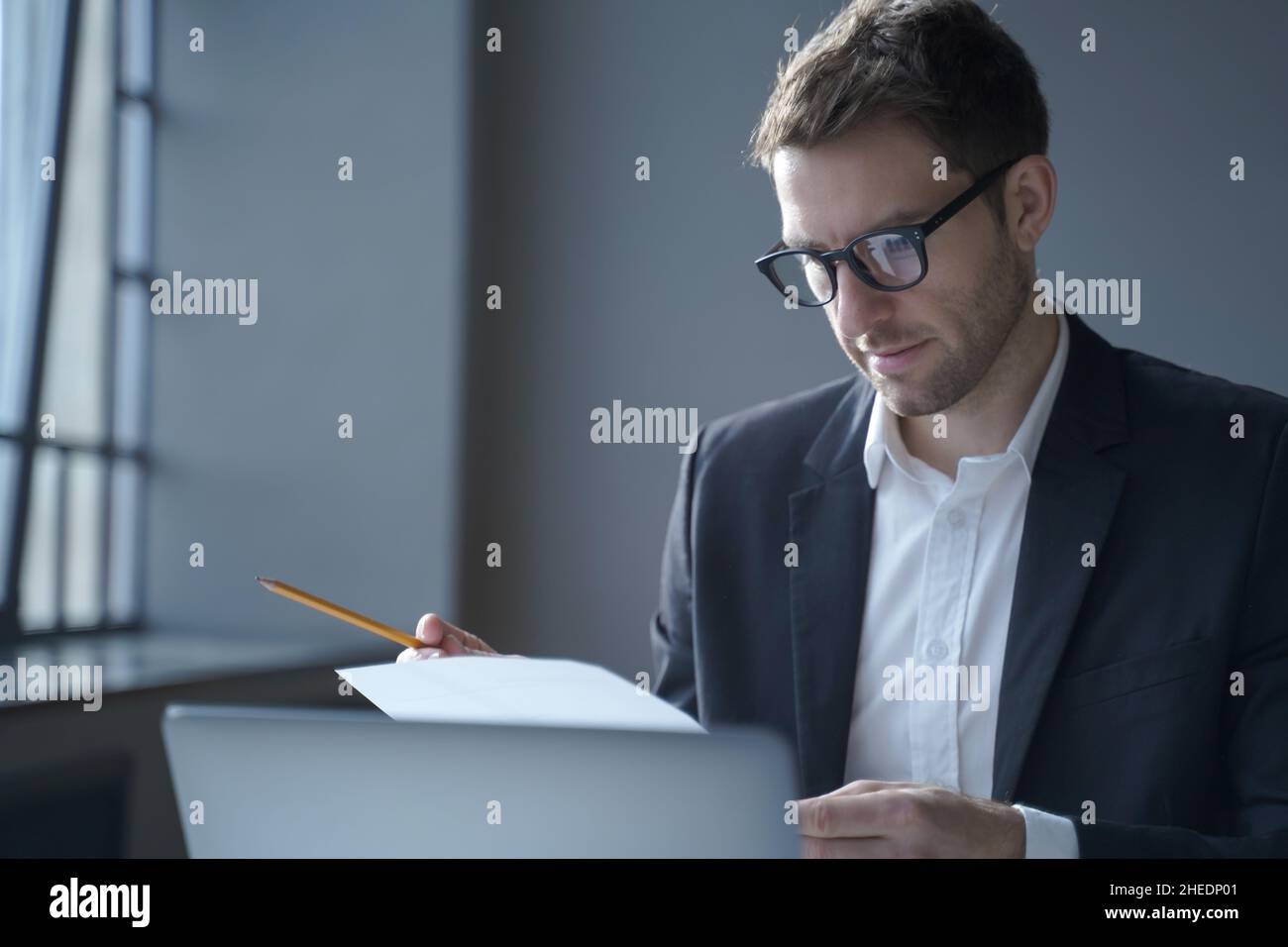 Serious male professional analyzing documents at workplace. Business and job concept Stock Photo