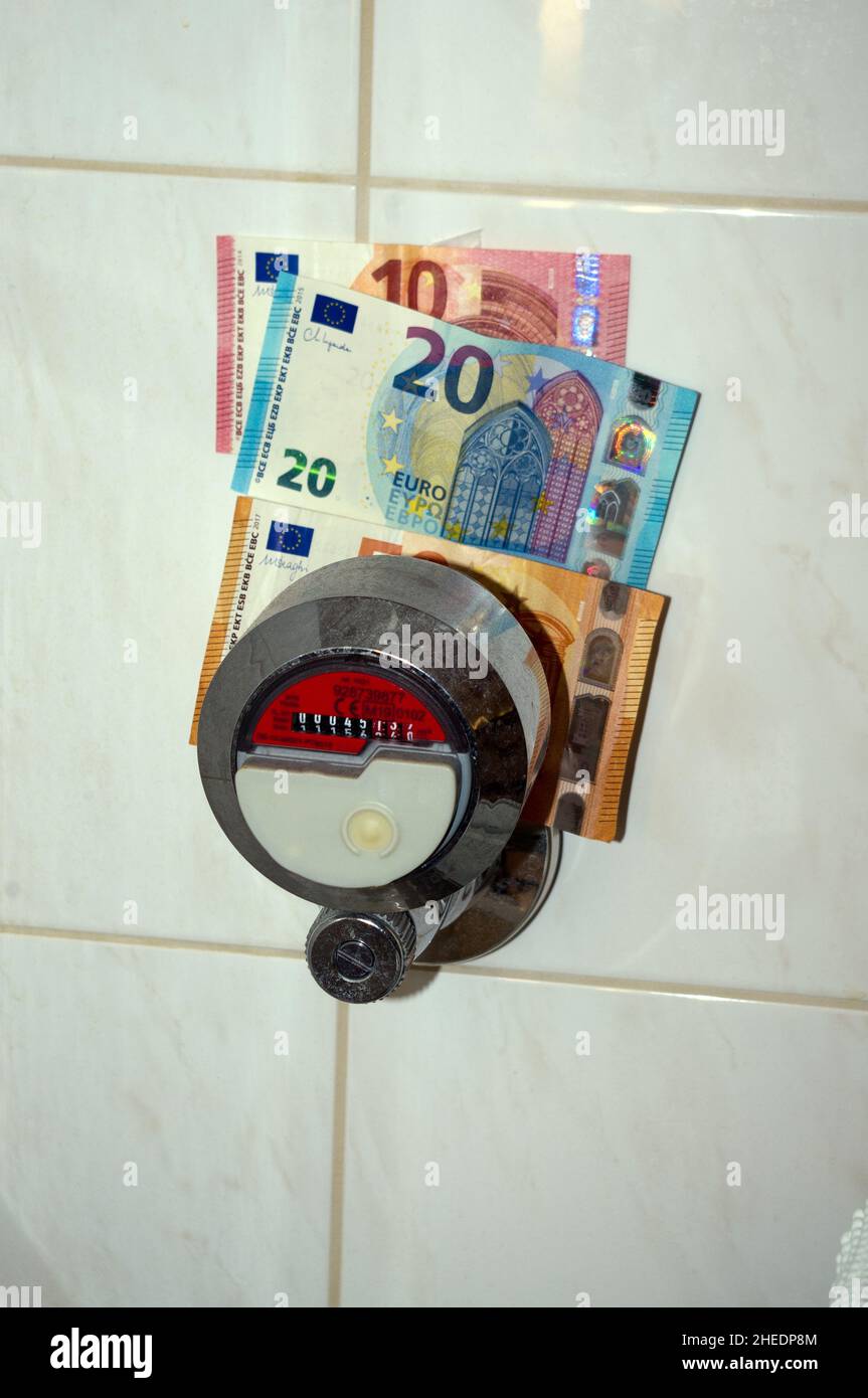 Symbolic image rising energy costs: hot water meter and banknotes Stock ...
