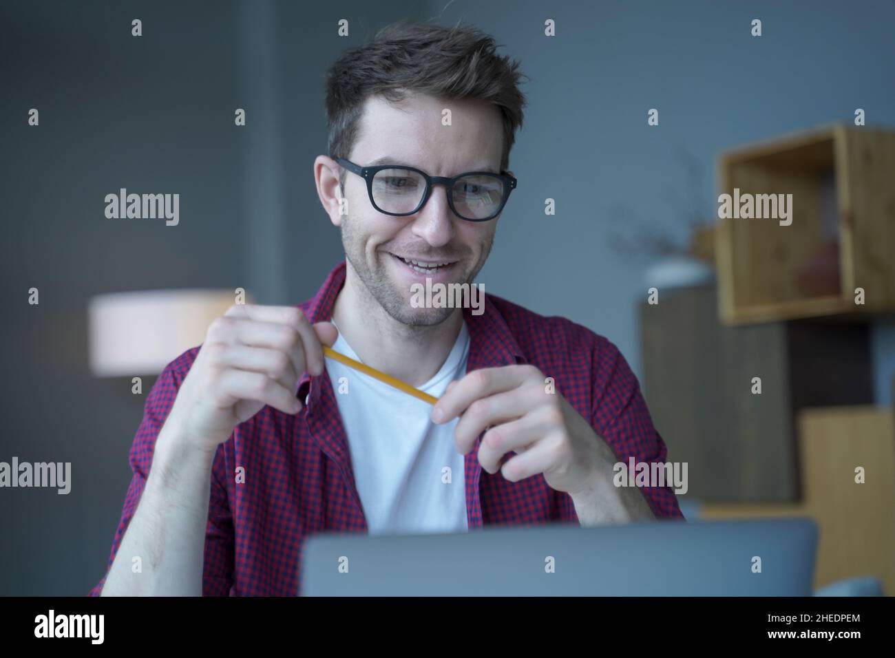 Portrait of joyful Austrian tutor in glasses having german language video classes online Stock Photo