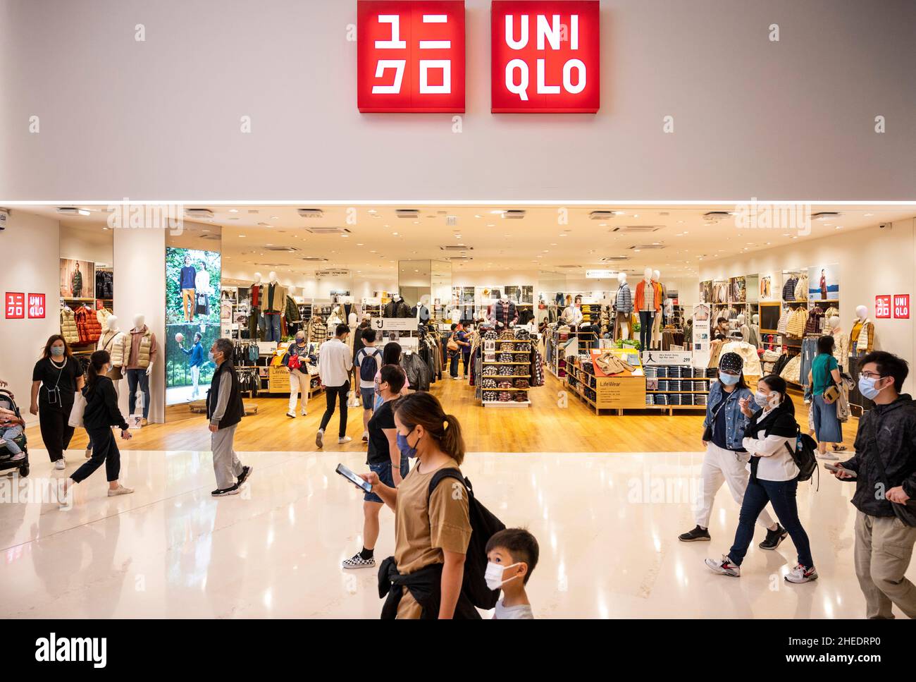 Shoppers walk past the Japanese clothing brand Uniqlo logo and store in  Hong Kong Stock Photo - Alamy
