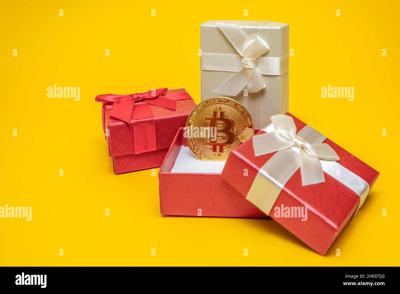 BTC gift. Bitcoin coin in a red gift box on a yellow background. Postcard  for printing, banner with place for text Stock Photo - Alamy