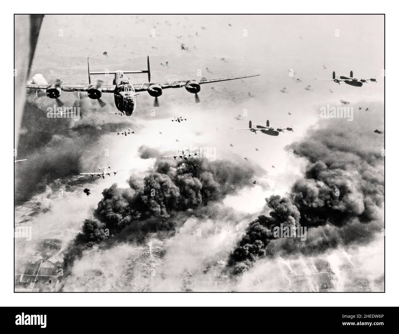 WW2 Bombing run heroic American Airforce B-24 Liberators flying through flak and over the destruction created by waves of bombers, 15th Air Force B-24s leave Ploieşti, Romania, after one of many attacks against the leading oil refinery target in continental Europe. (U.S. Air Force photo) LOC caption: 'Waves of Consolidated B-24 liberators of the 15th AAF fly over the target area, the Concordia Vega Oil refinery, Ploești, Romania, with bursting flak, after dropping their bomb loads on the oil plant,  31 May '44'  The  mission was deemed a success, though 54 of the 177 bombers didn't return Stock Photo