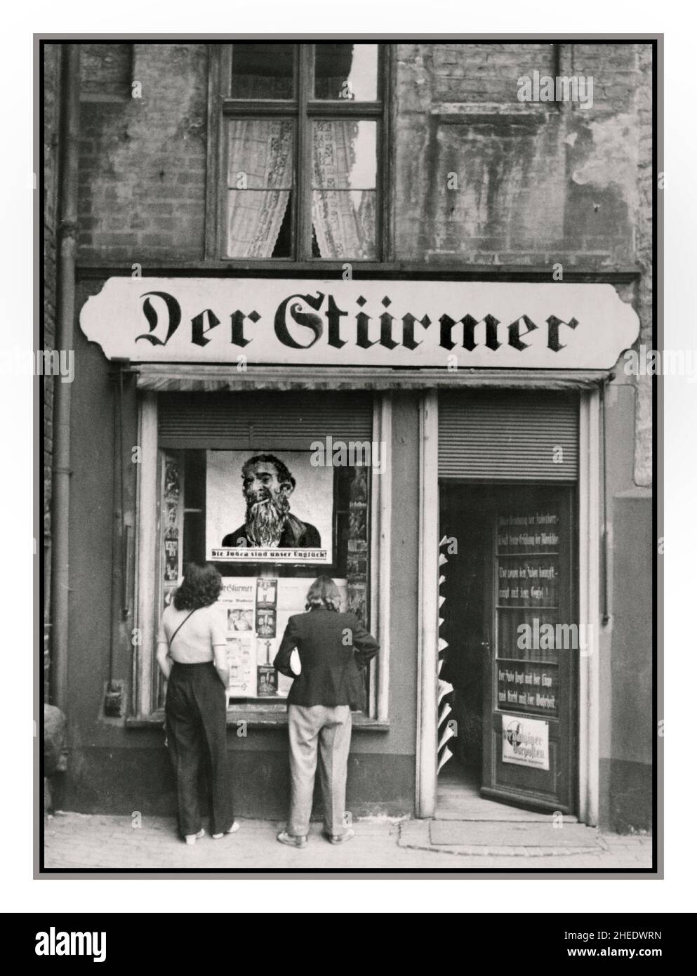 DER STURMER NSDAP Nazi Anti Jewish Racist Propaganda Newspaper outlet offices of Nazi newspaper DER STURMER Gdansk in Poland, 1930s. An anti-Semitic poster displayed in the window reads 'Die Juden sind unser Ungluck!' ('The Jews are our misfortune'  Der Stürmer Tabloid Newspaper Weekly German newspaper published by Julius Streicher, the Gauleiter of Franconia, from 1923 to the end of World War II Nuremberg Nazi Germany During WW2 Streicher regularly authorized articles demanding annihilation and extermination of the Jewish race. Der Stürmer was best known for its anti-semitic caricatures, Stock Photo