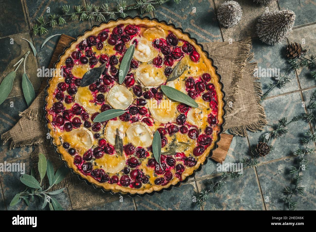 Cranberry goat cheese tart with sage on rustic blue background, top view Stock Photo