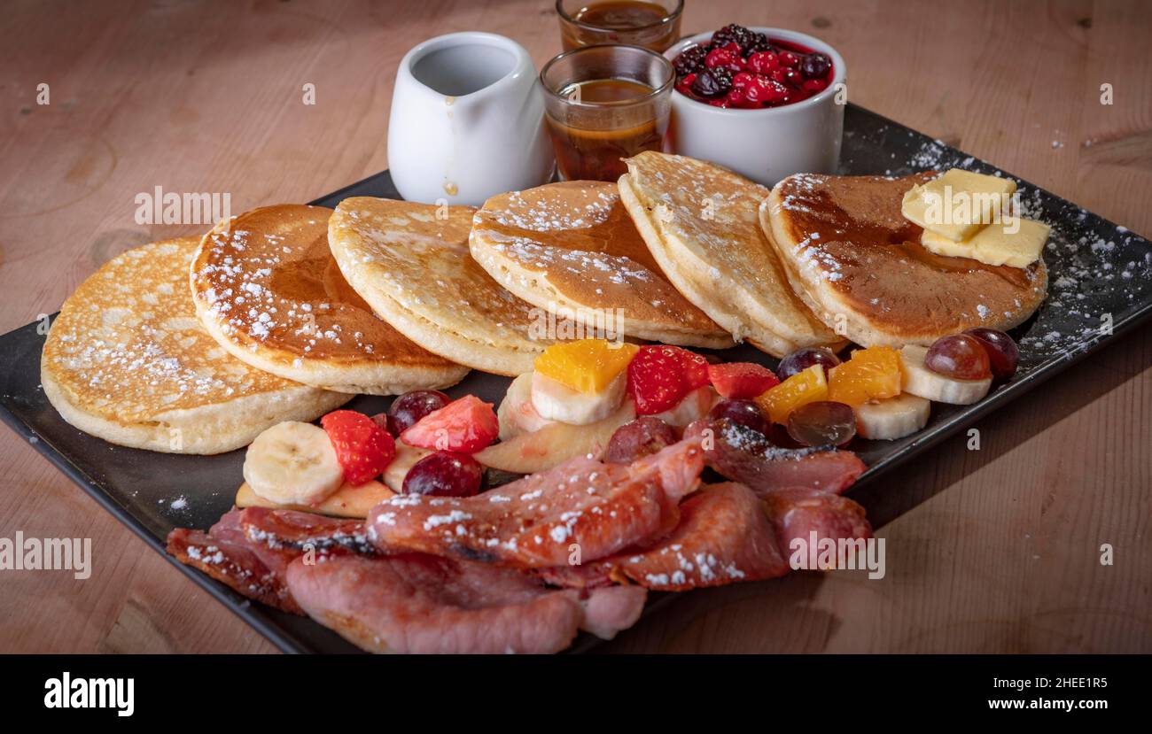 Pancakes and strawberry tarts with cream. Stock Photo