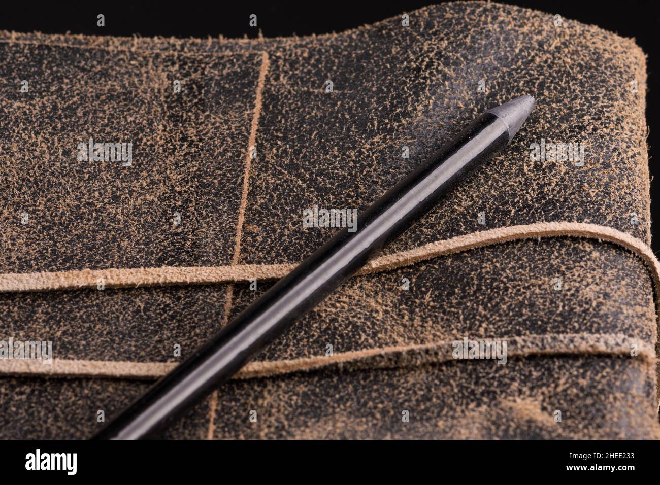 Black pencil on a leather-bound diary Stock Photo