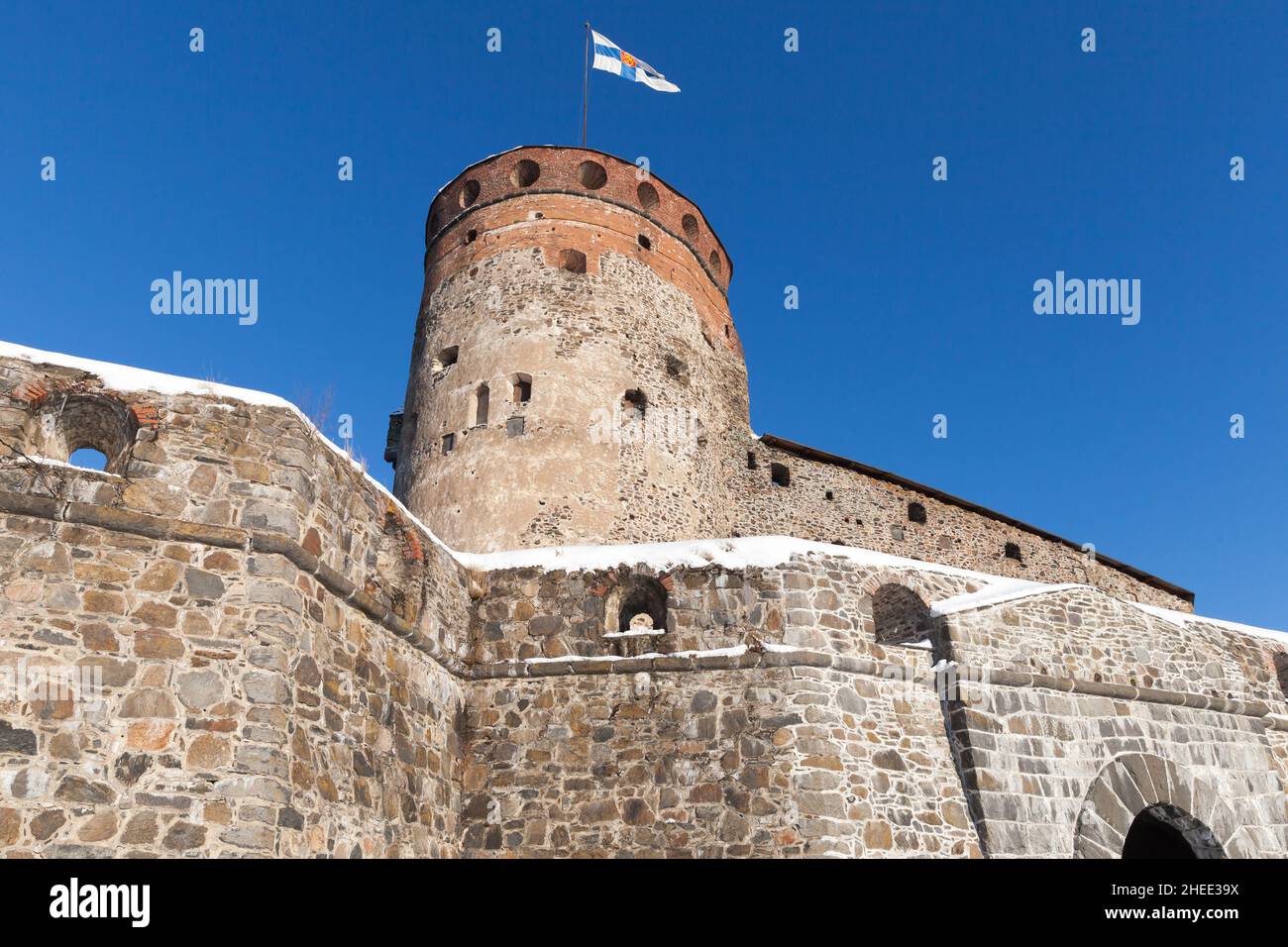 Olavinlinna is under blue sky on a sunny day. It is a 15th-century three-tower castle located in Savonlinna, Finland. The fortress was founded by Erik Stock Photo