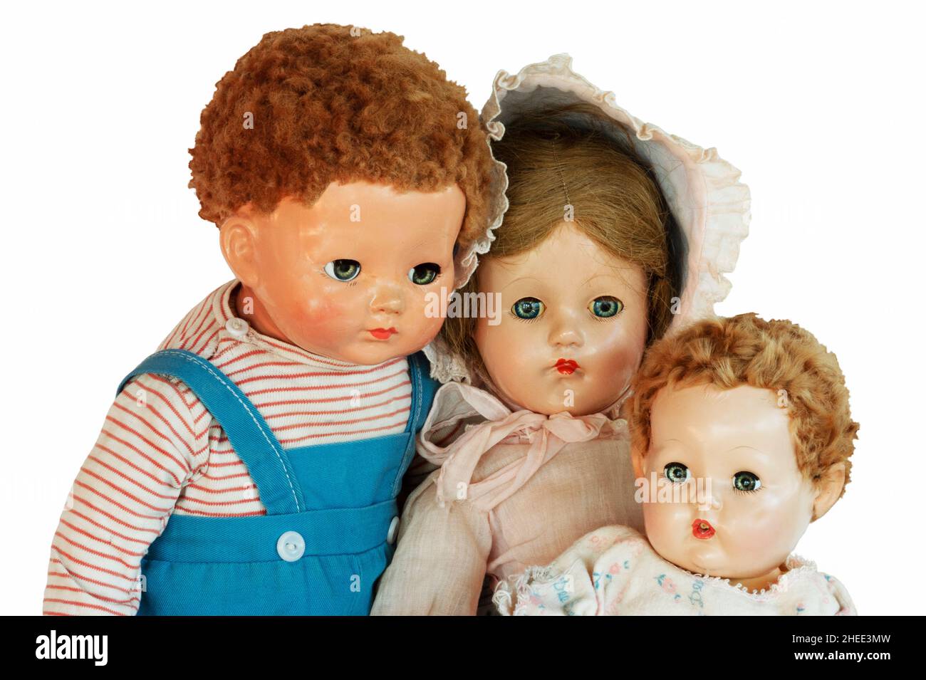 Three vintage dolls with original clothes and  hair. They have china, porcelain, and hard plastic heads  from 1930-1950 with a blowing bubble doll. Stock Photo