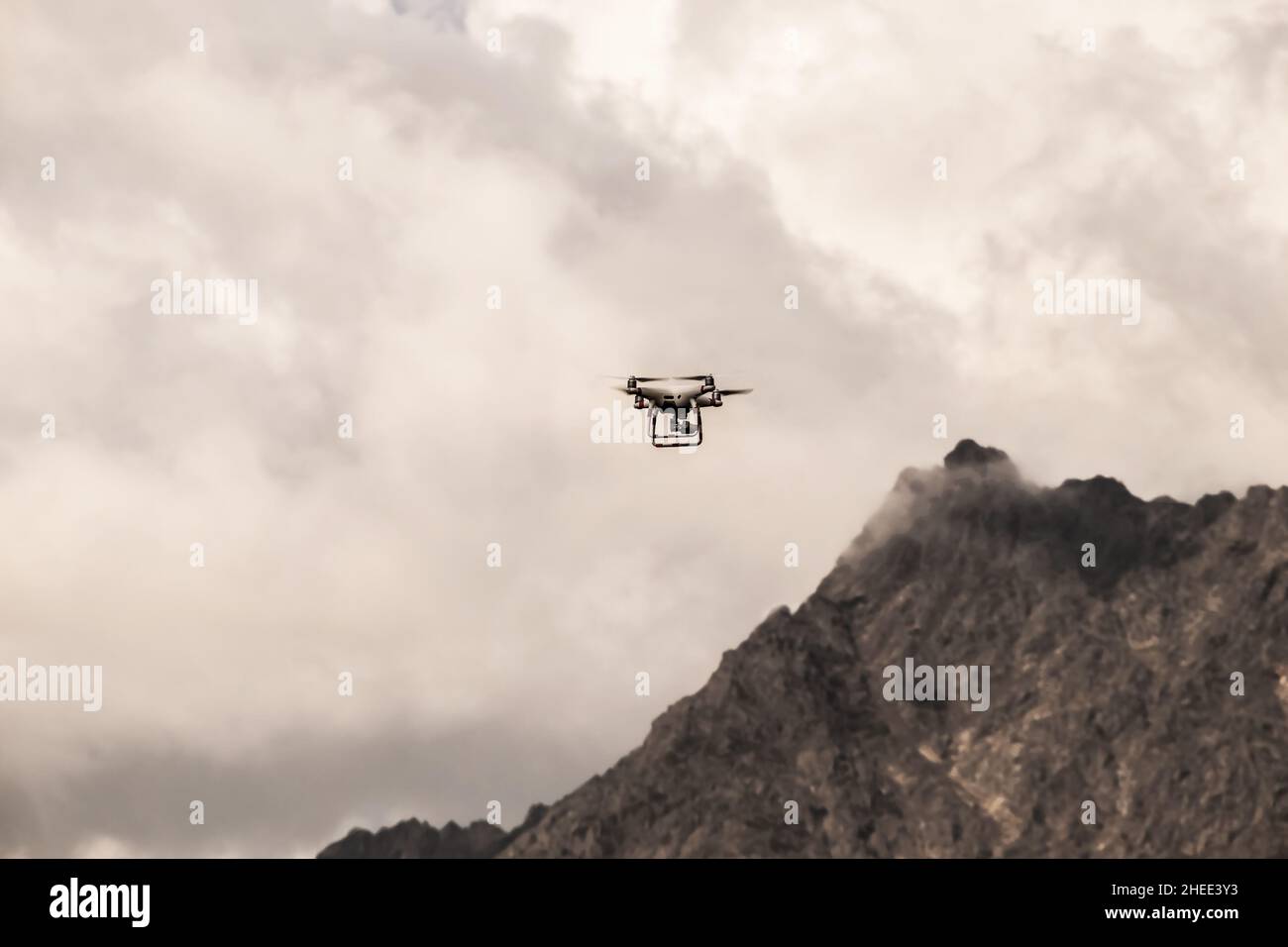 Drone flying up in high misty mountains - focus on foreground with blurry background Stock Photo