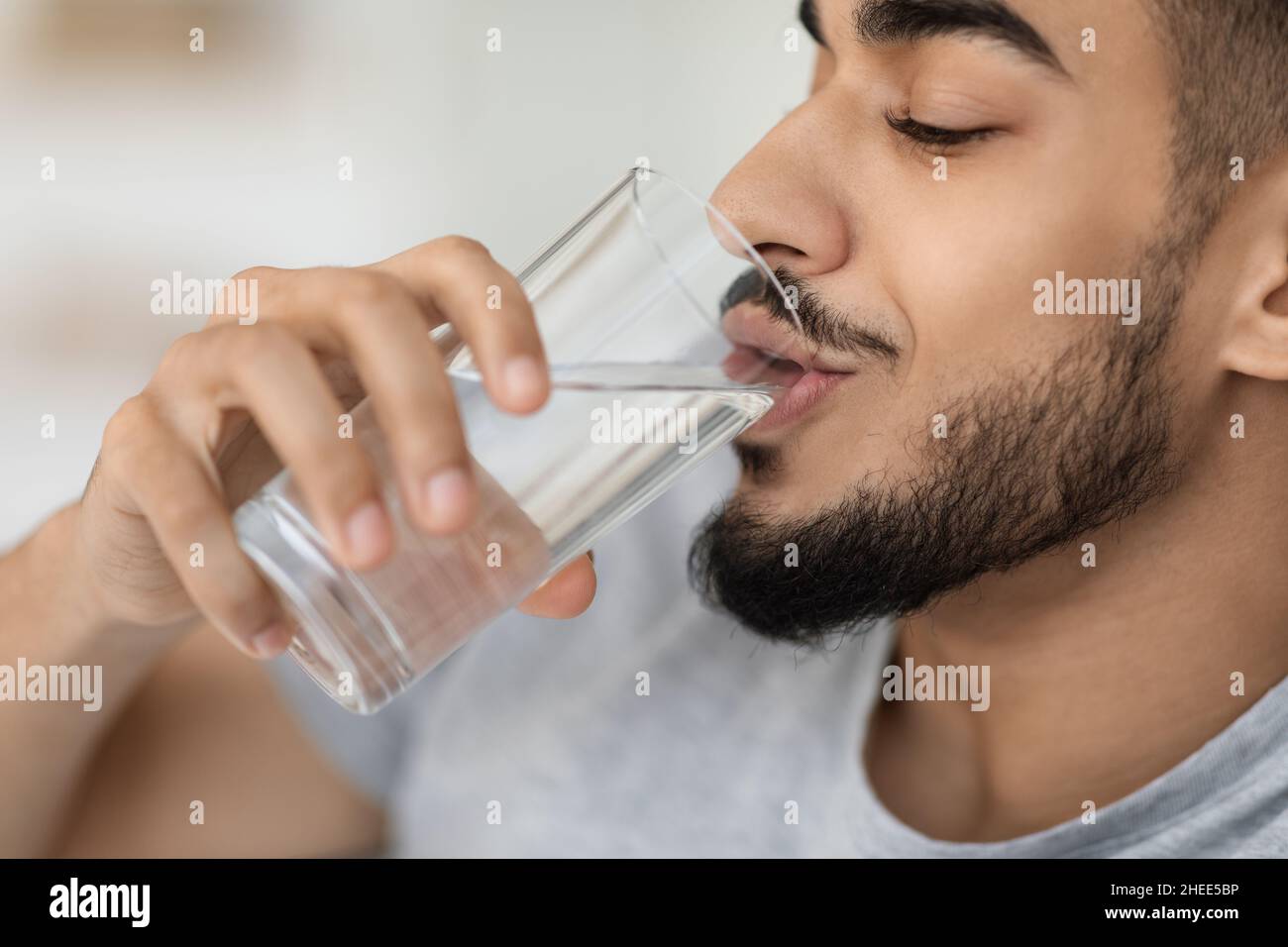 Healthy Liquid. Portrait Of Handsome Arab Man Drinking Mineral Water From Glass Stock Photo