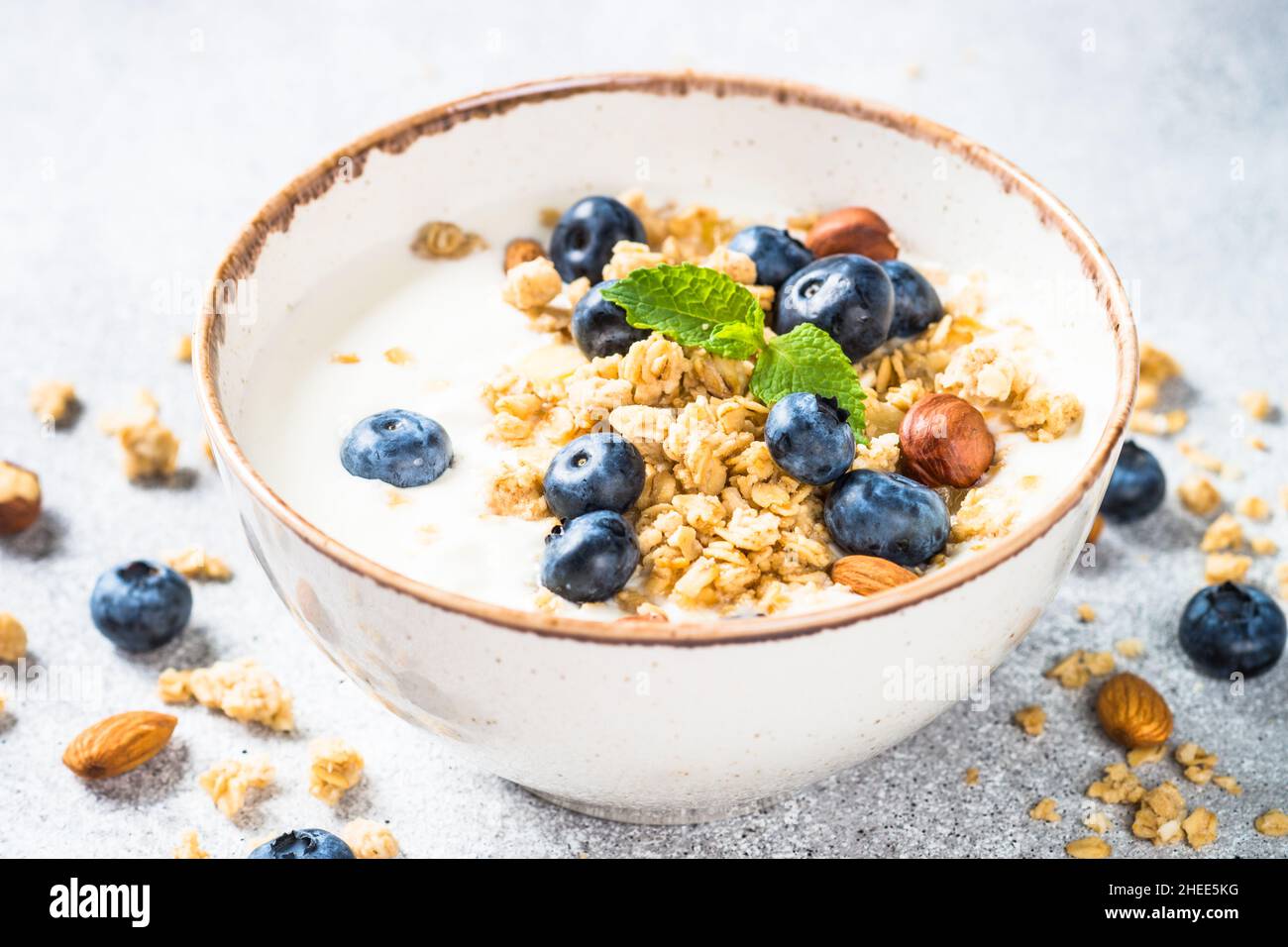 Yogurt granola with fresh blueberries on stone table. Stock Photo