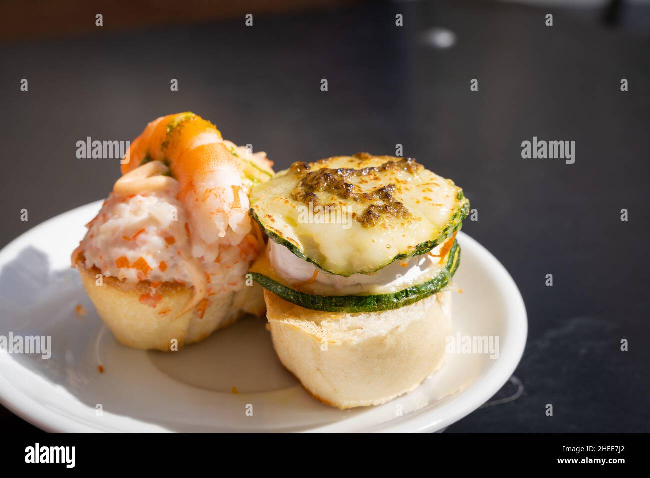 Delicious Spanish tapas on plate with bread, prawn, cheese and zucchini on  top. Restaurant food, bar snack, gourmet concepts Stock Photo - Alamy