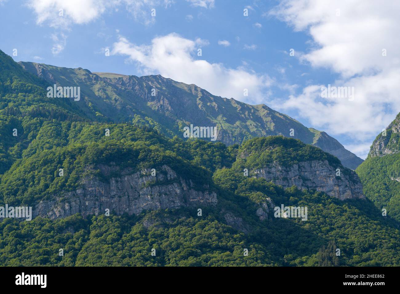 This landscape photo was taken in Europe, in France, in Isere, in the Alps, in summer. We can see the white clouds above the Massif des Bauges, under Stock Photo