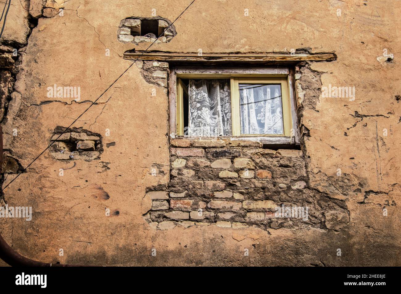 Upper story window with pretty lace curtains and one page open in very ...