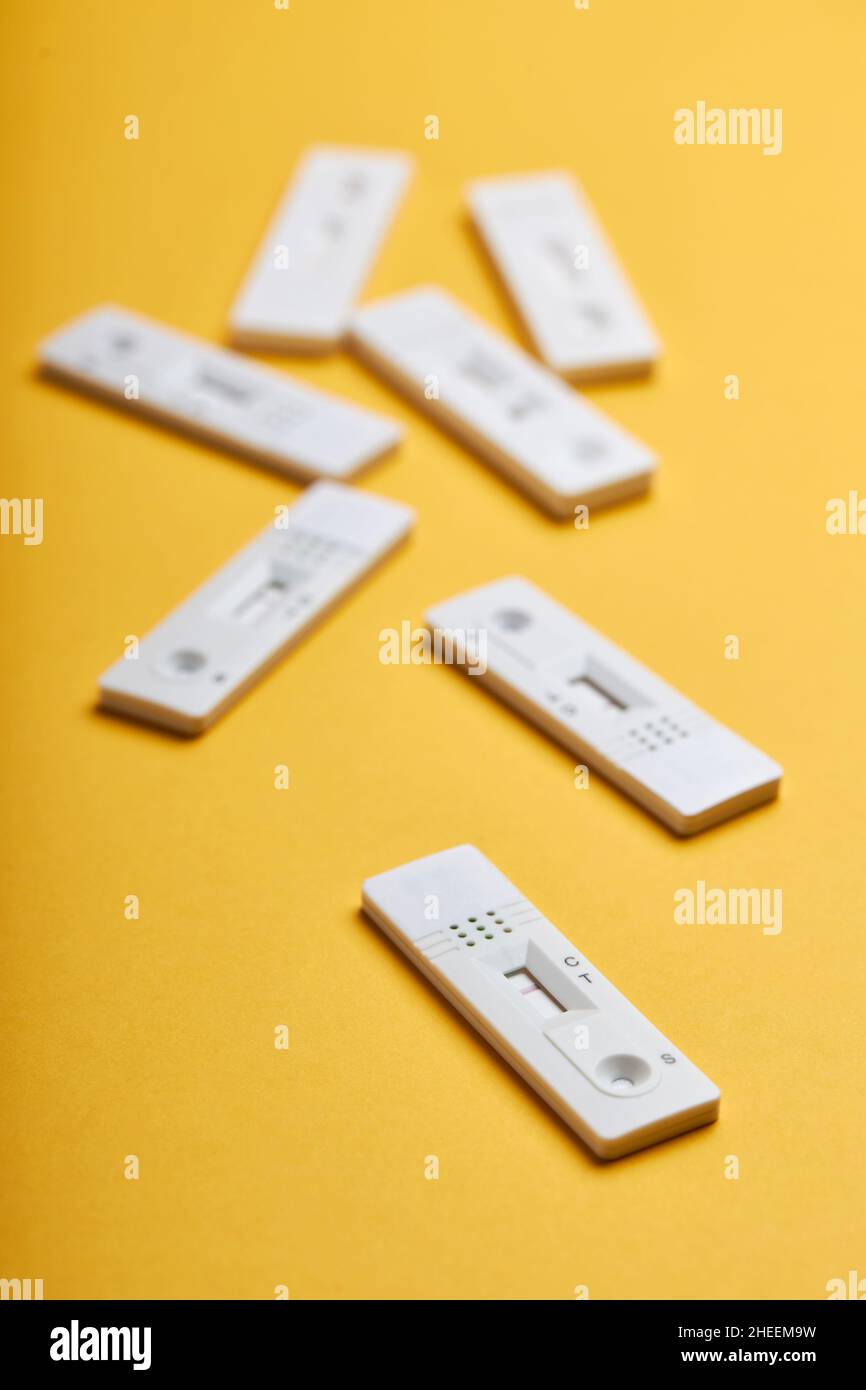 Yellow background with various covid negative rapid tests Stock Photo