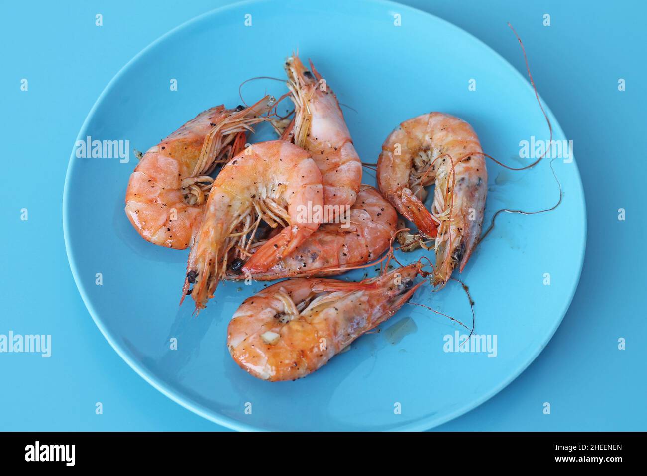 Boiled shrimps on blue plate. Healthy sea food. Stock Photo