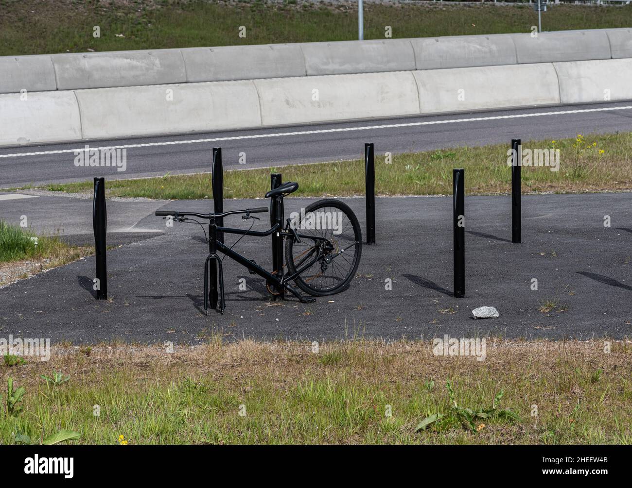 Black bicycle locked to a bicke rack. Front wheel stolen Stock Photo