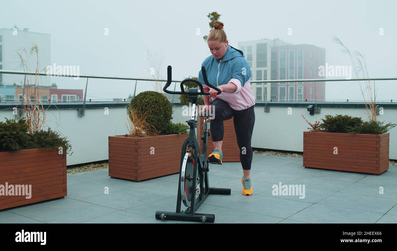 Athletic woman riding on spinning stationary bike training routine on