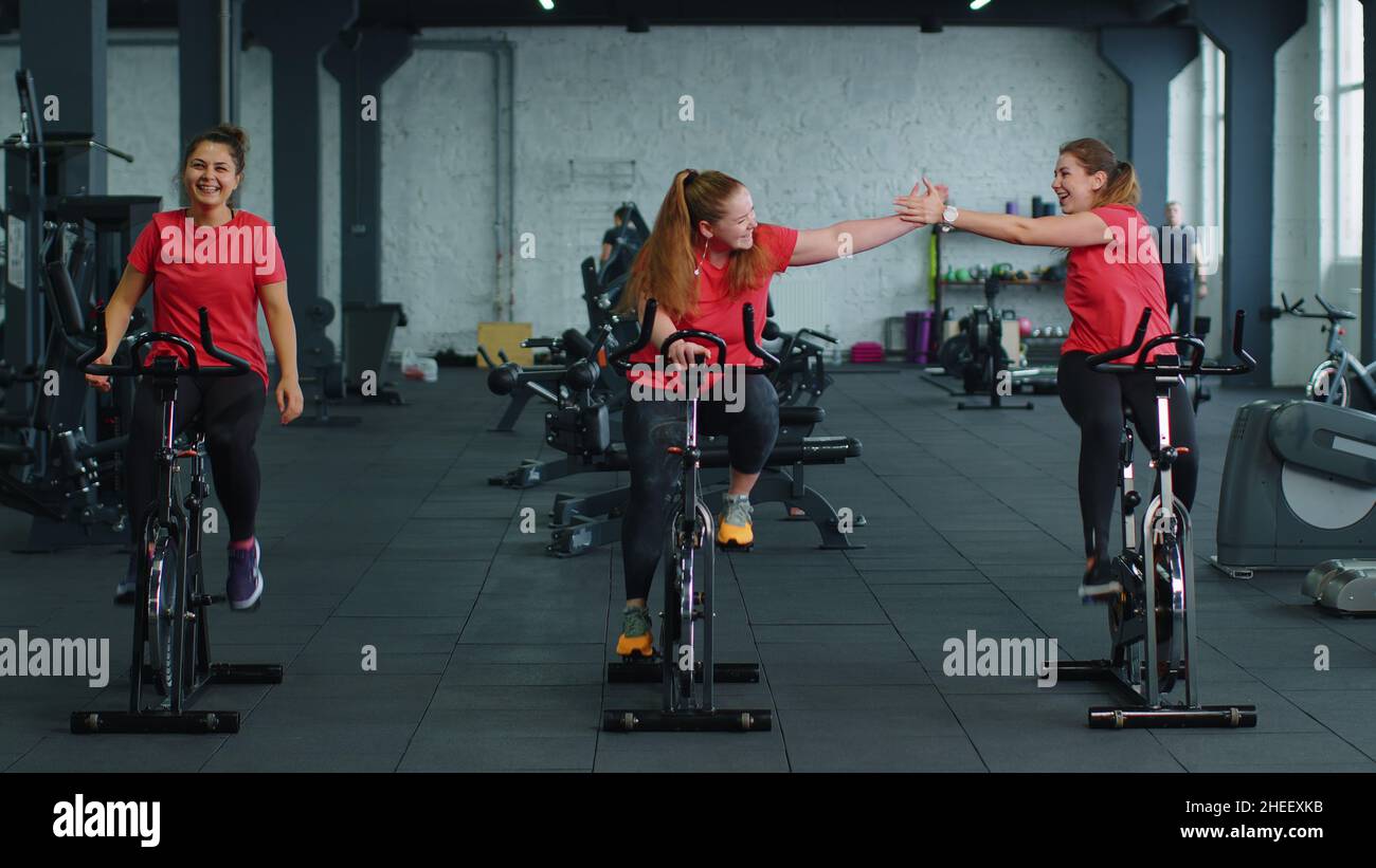 Group of smiling friends women class exercising, training, spinning on
