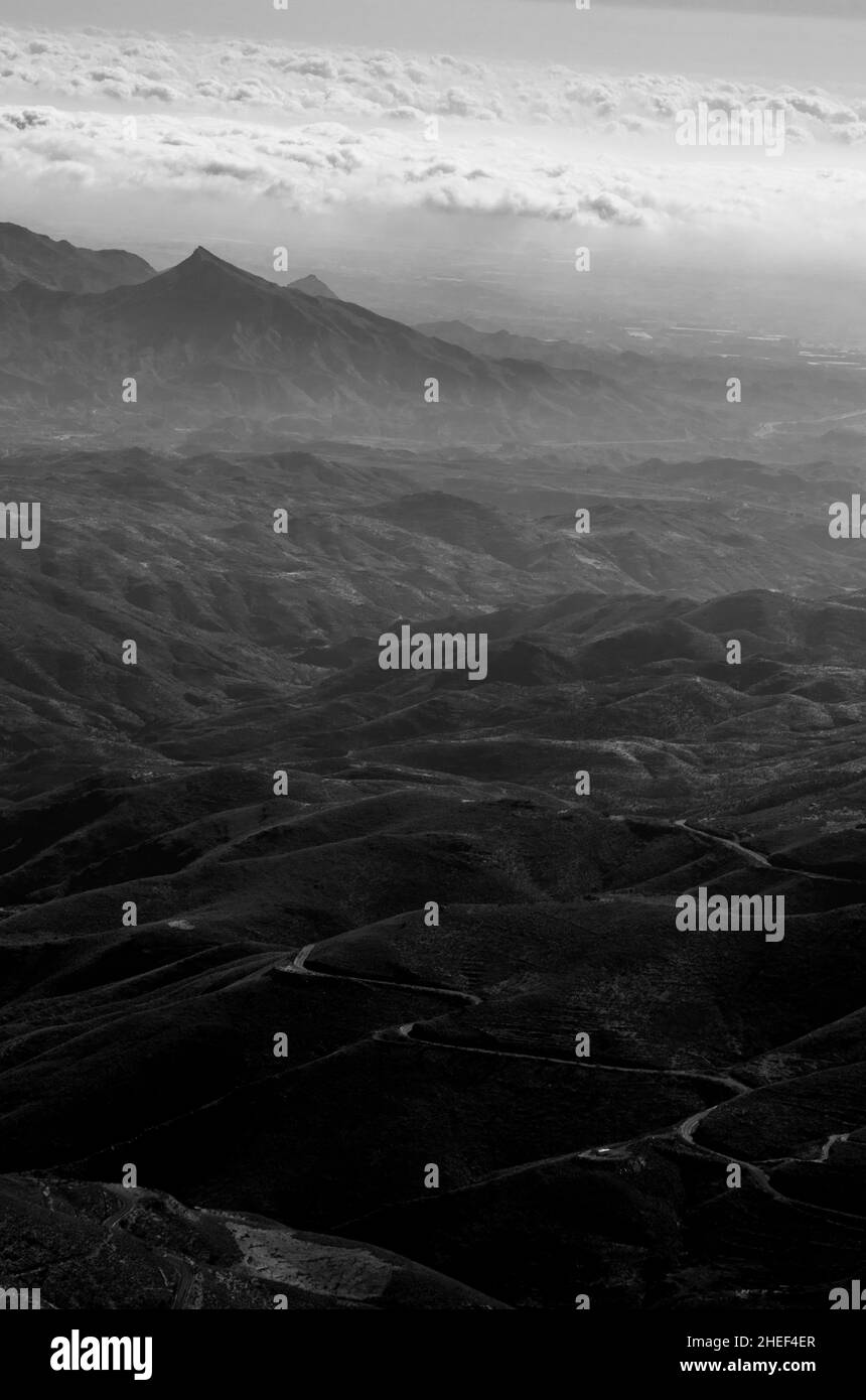 mountains, valleys and gorges of a desert where a desolate path crosses the wasteland Stock Photo