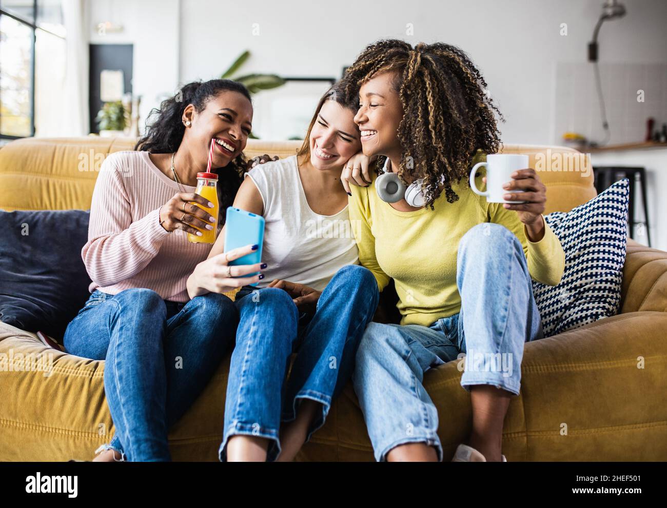 Cheerful multiracial female friends enjoying free time together at home Stock Photo