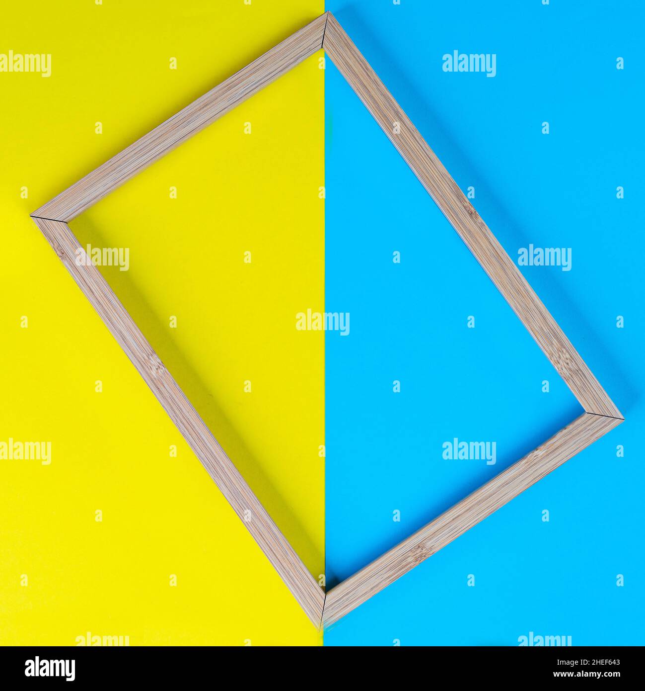 a wooden frame on a background of colored shapes Stock Photo